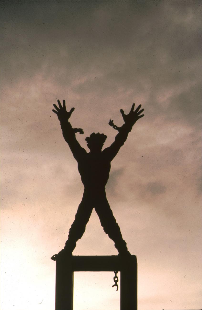 BD/166/260 - 
Standbeeld van figuur met losgerukte ketens
