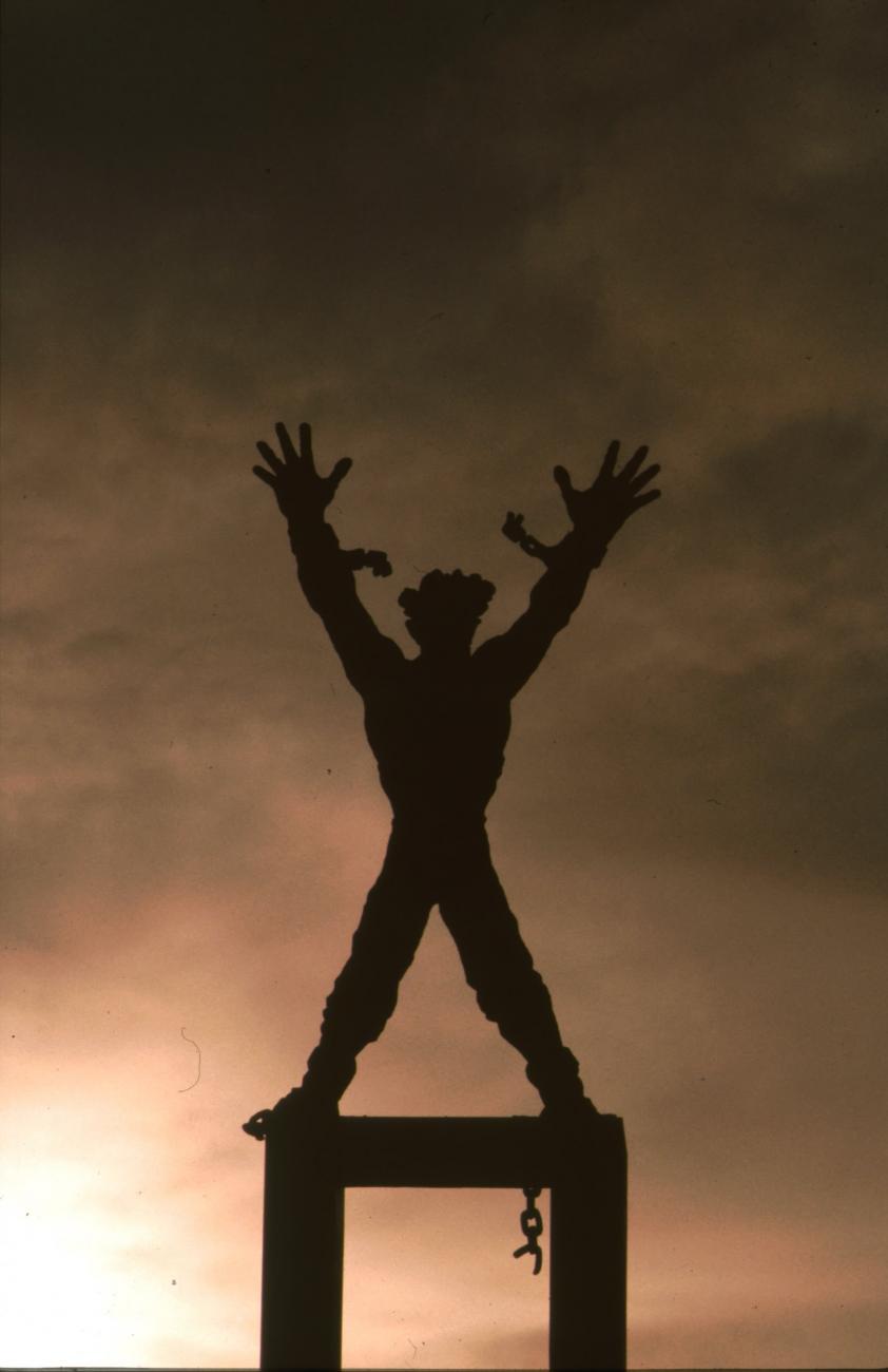 BD/166/260 - 
Standbeeld van figuur met losgerukte ketens
