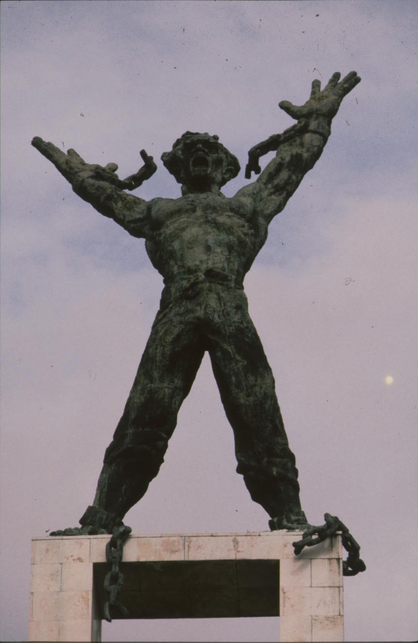 BD/166/260 - 
Standbeeld van figuur met losgerukte ketens
