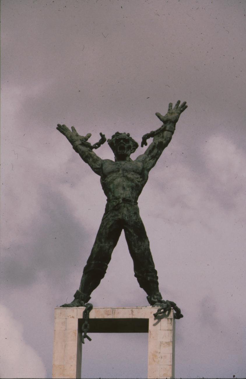 BD/166/260 - 
Standbeeld van figuur met losgerukte ketens
