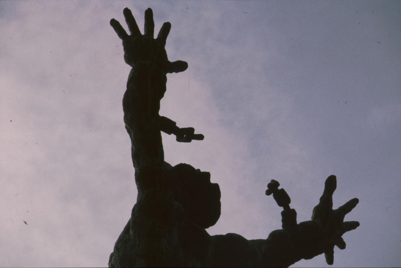 BD/166/261 - 
 Close-up standbeeld van figuur met losgerukte ketens
