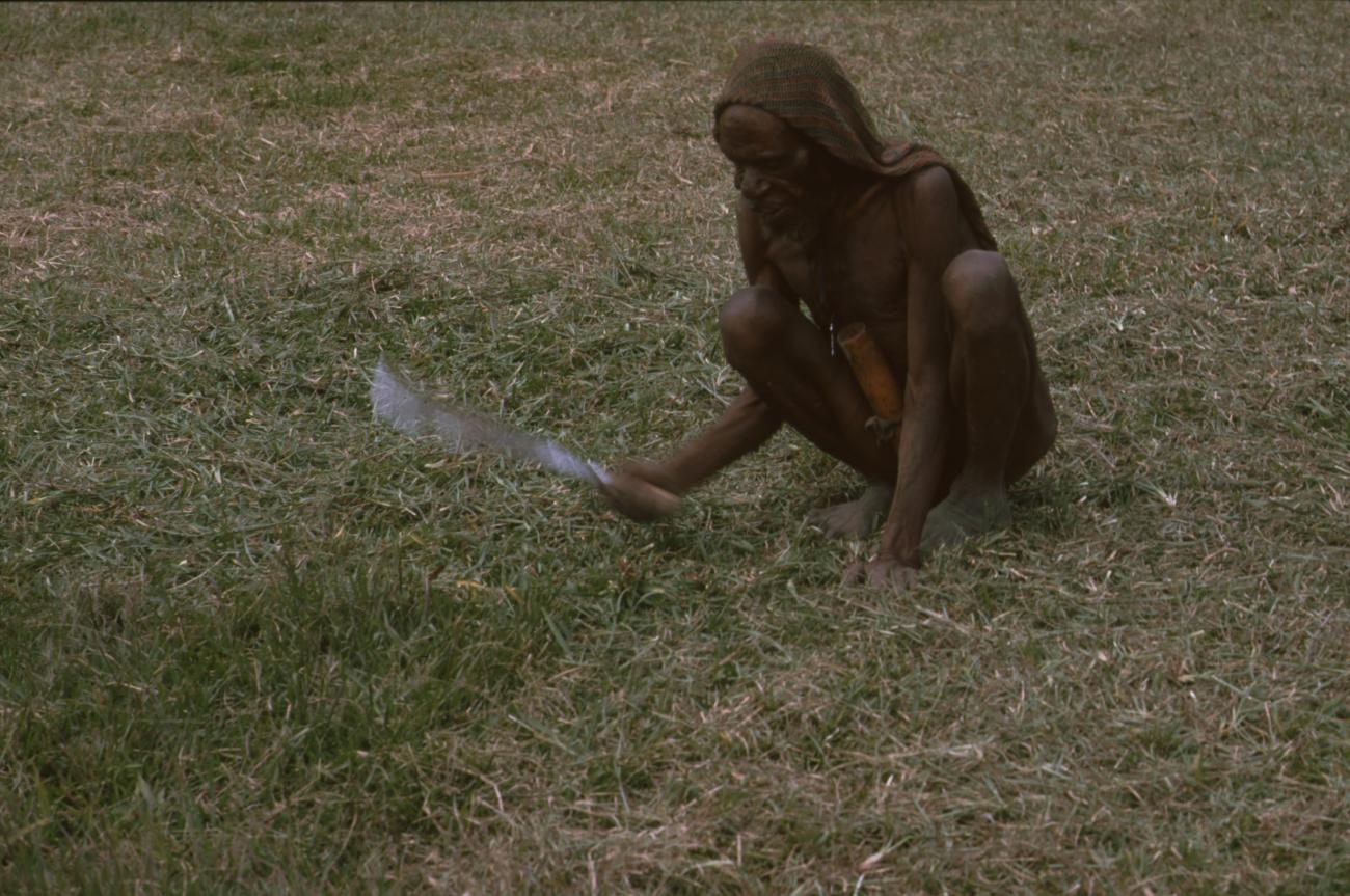 BD/166/377 -
Papua man is cutting his grass in a squating position