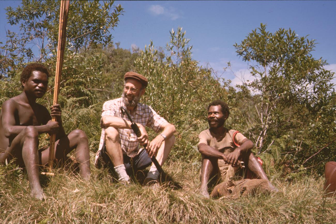 BD/132/172 -
pater Andringa met paraplu tussen twee Papua's