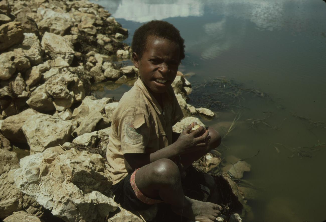 BD/132/38 -
portretfoto van jongen zittend bij water