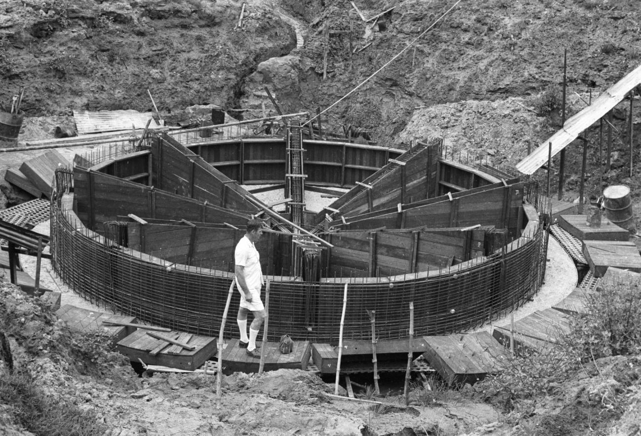 BD/133/1002 - 
Westerse beambte bij wat mogelijk waterzuiveringsinstallatie in aanbouw is
