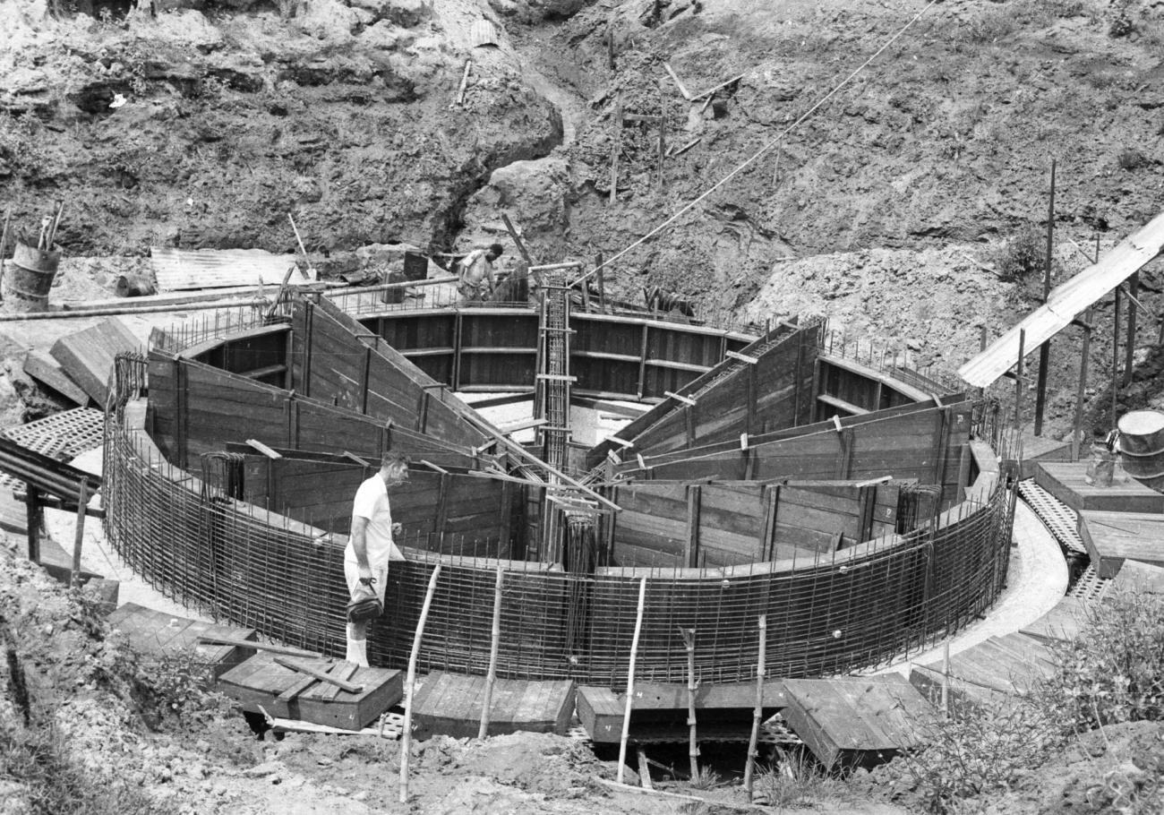 BD/133/1003 - 
Westerse beambte bij wat mogelijk waterzuiveringsinstallatie in aanbouw is
