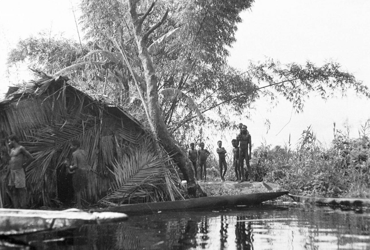 BD/133/291 - 
Tocht Merauke-Kepi-Cook: Hut met prauwen aan het water

