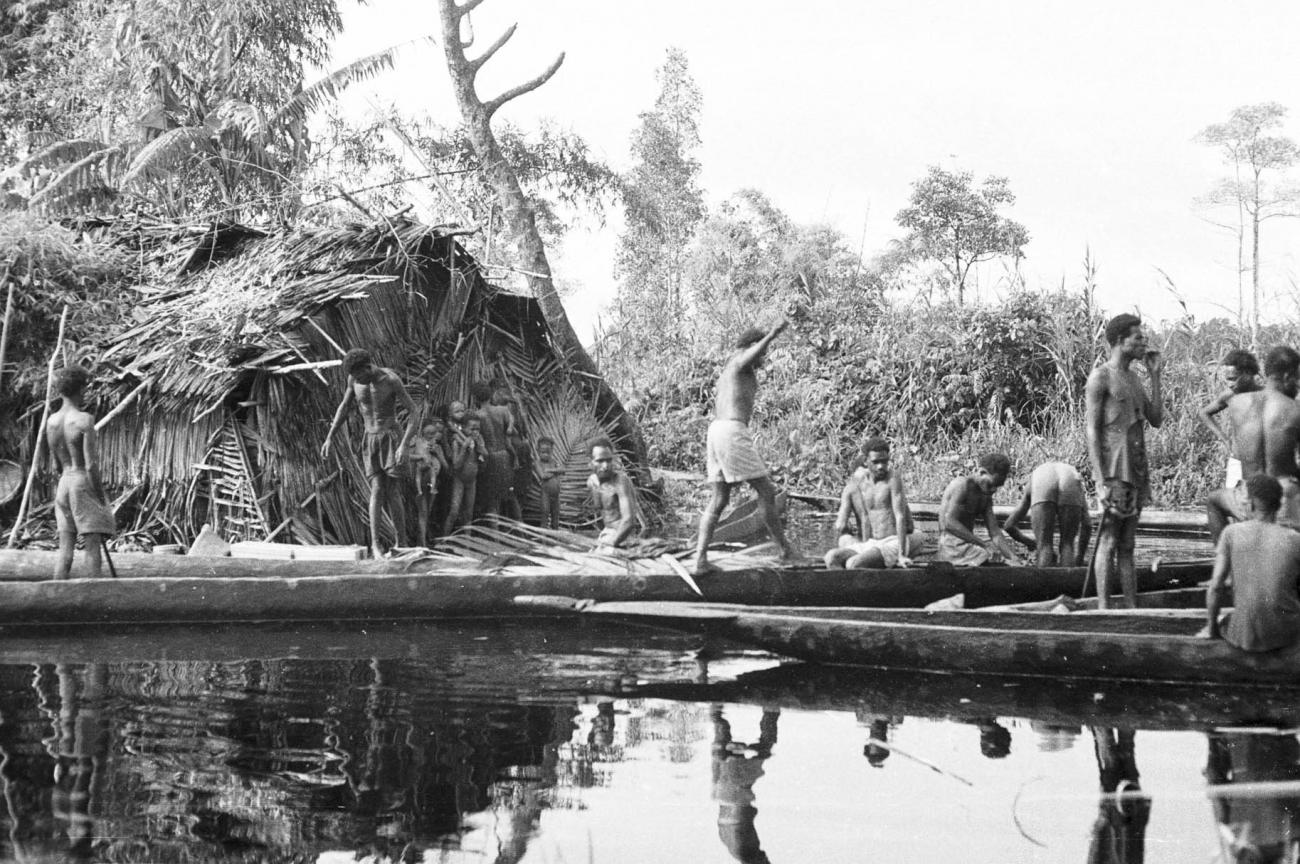 BD/133/293 - 
Tocht Merauke-Kepi-Cook: Hut met prauwen aan het water
