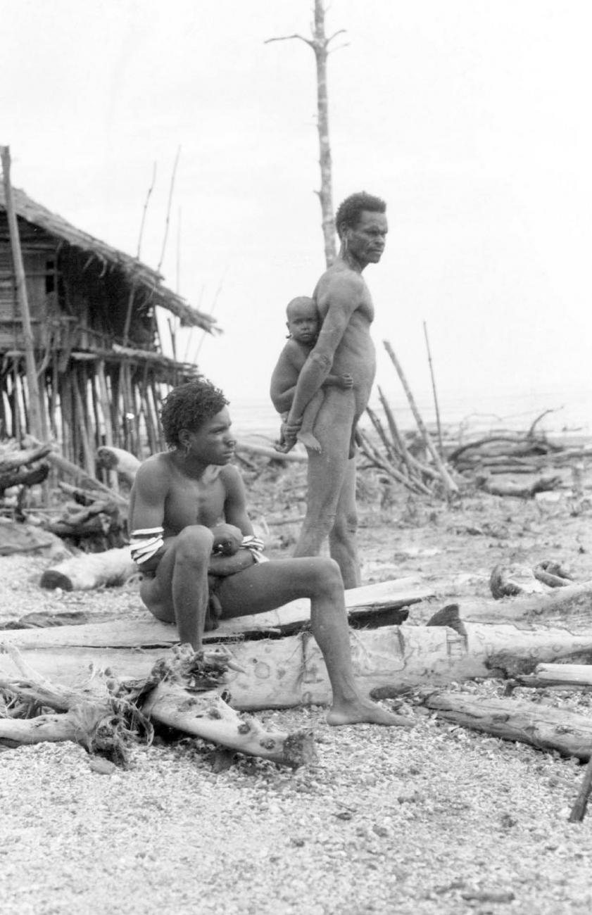 BD/133/42 -
Tocht Merauke-Kapi: Opname van twee Marind_anim mannen met peuter op rug