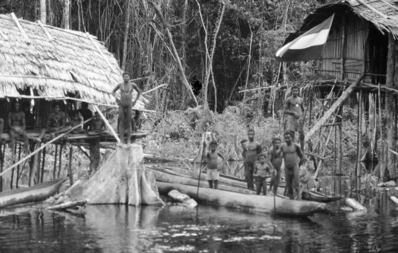 BD/133/50 -
Tocht Merauke-Kapi: Marind-anim mensen staande in prauwen aan de oever
