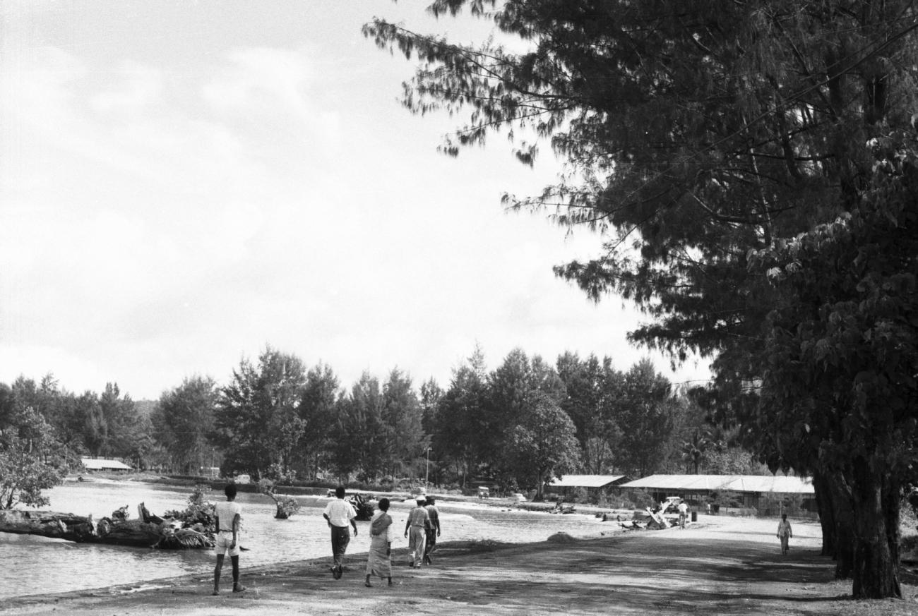 BD/133/901 - 
Straatbeeld met langs de rivier wandelende mensen
