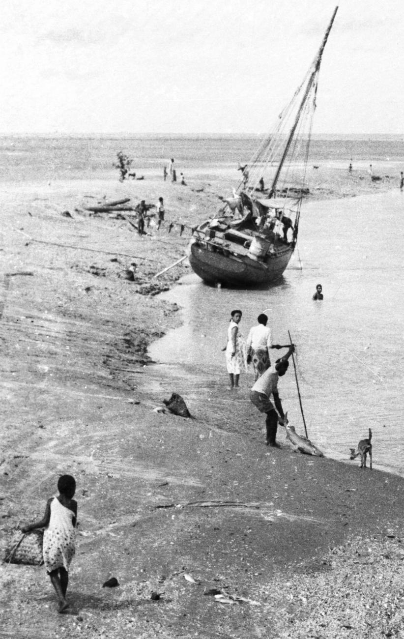 BD/133/955 - 
Getijdelandschap met met drooggevallen zeilschip en langs de oevers vissende Papoea&#039;s 
