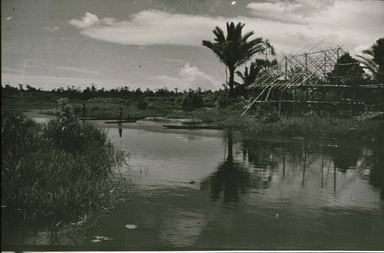 BD/309/211 -
Landschap met rivier en prauwen en op de oever huis in aanbouw