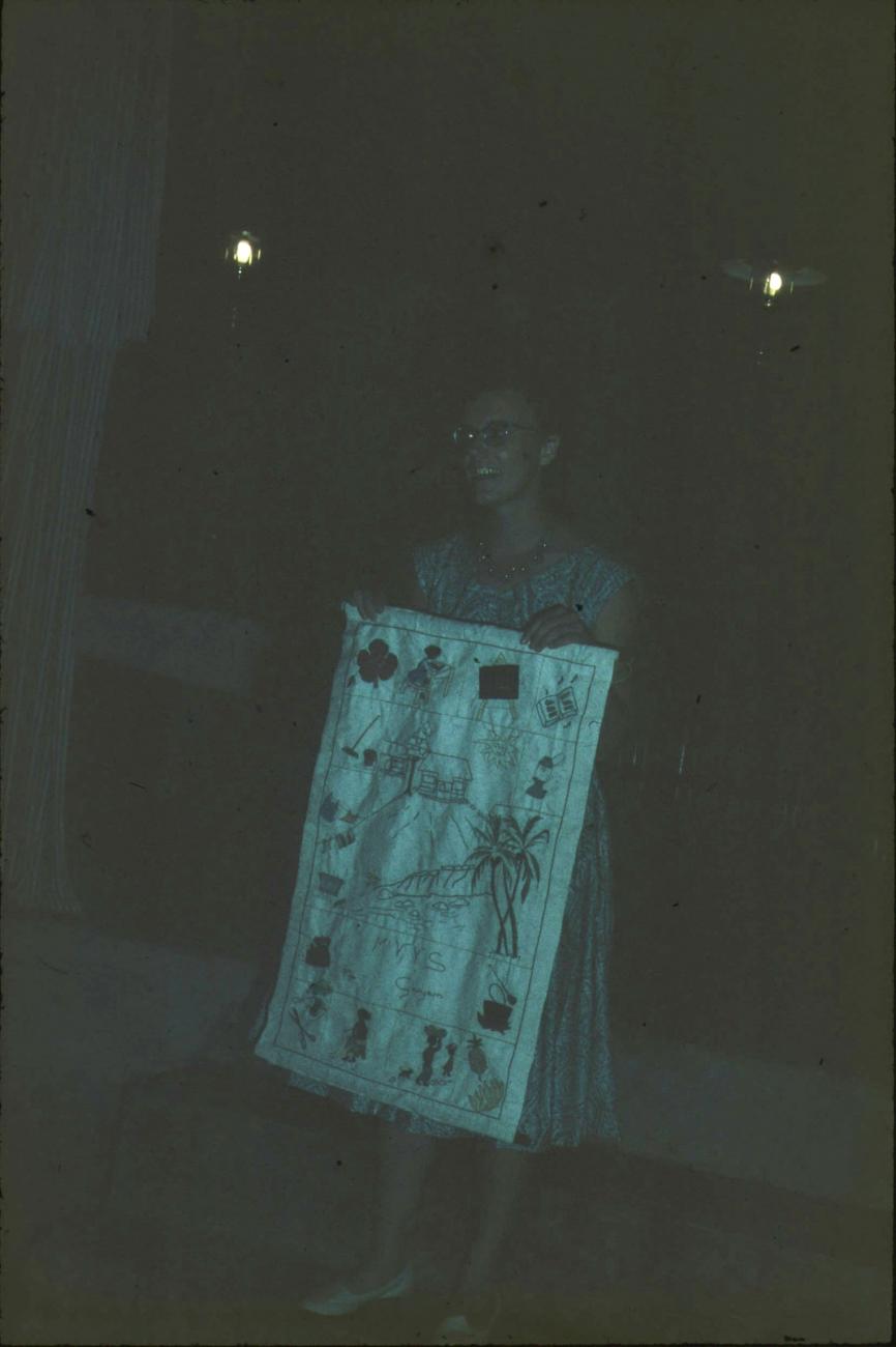 BD/171/1387 - 
Westerse vrouw met cadeau, beschilderd stuk stof.
