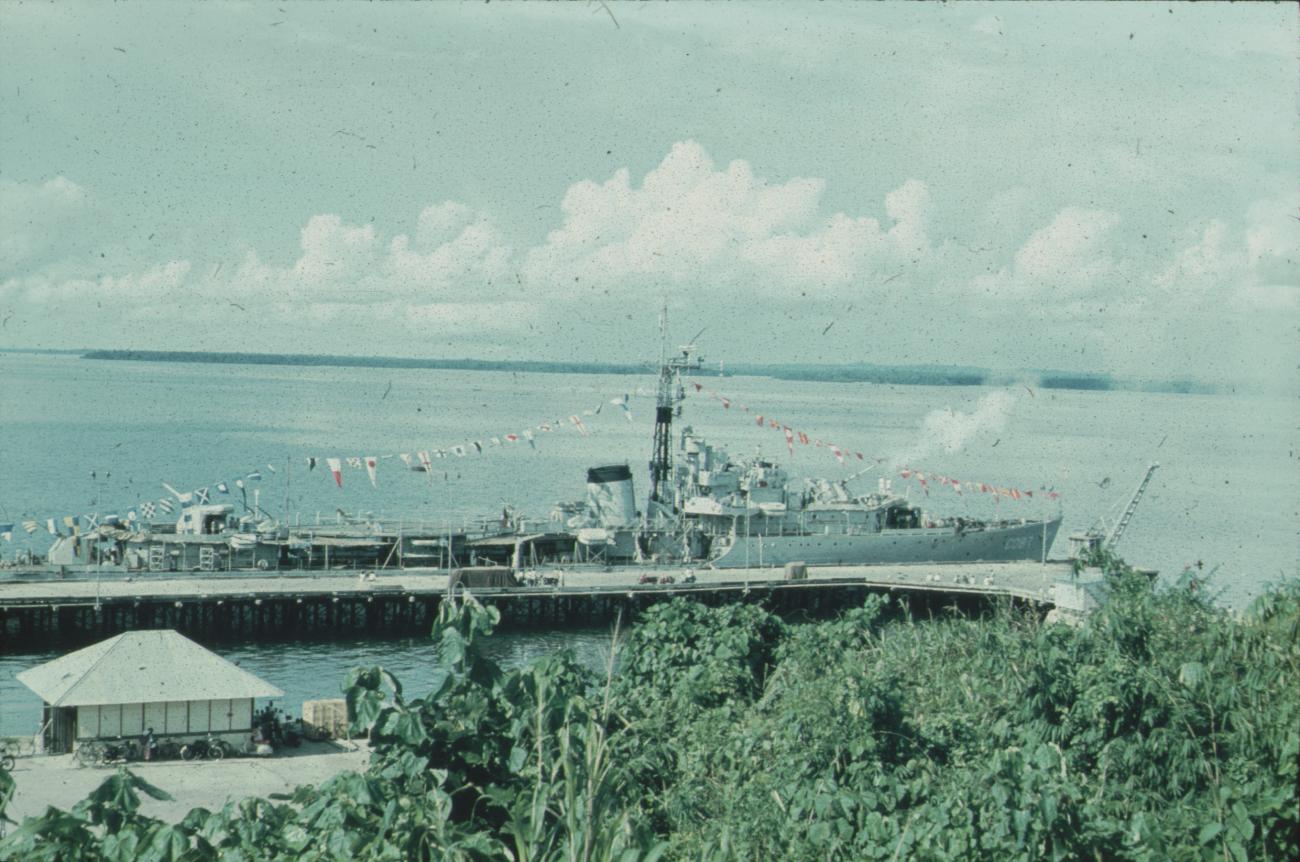 BD/171/651 - 
Gepavoiseerd marineschip aan aanlegsteiger.
