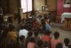BD/132/2 groepsfoto mensen  in kerk die luisteren naar man met microfoon